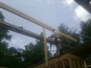 Carpenter setting a ridge beam over a new addition frame — Ice Dam Removal by Roofing Brothers in Sylvania