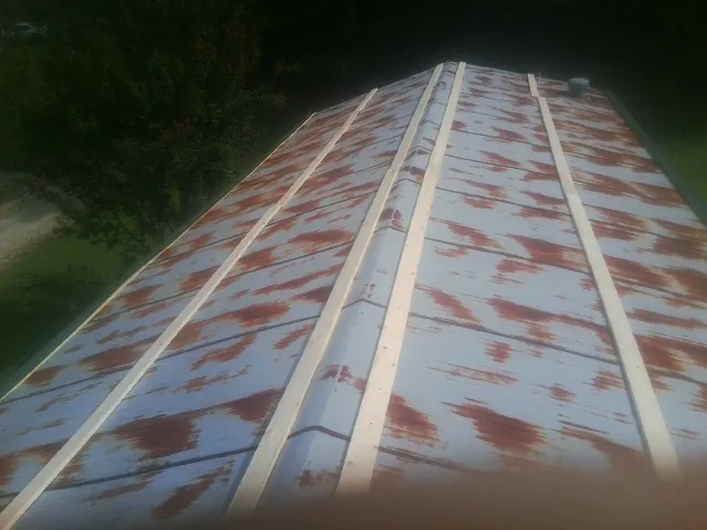 Rusted metal roof panels with new wood purlins before replacement — Storm Damage Roof Repair in Sylvania by Roofing Brothers
